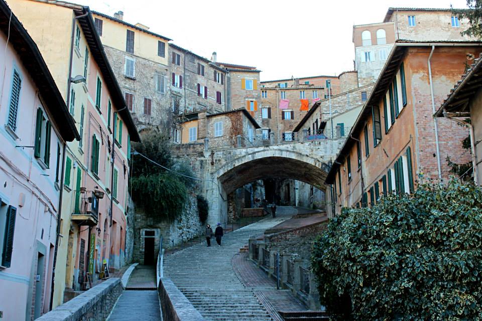 street with stairs in perugia with an arch and beautiful colorful buildings