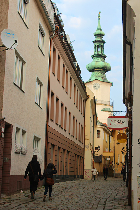 two locals walking in a street of the old town of bratislava 